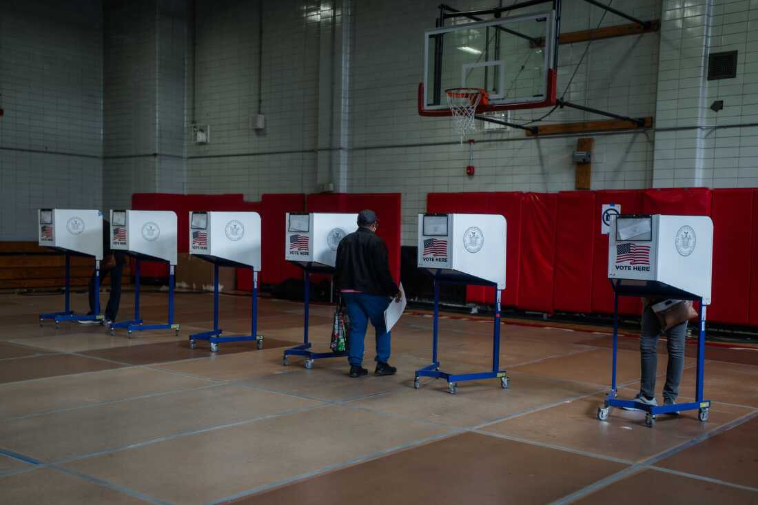 A voter carries a ballot during early voting for New York City's mayoral election on Oct. 25, 2025.