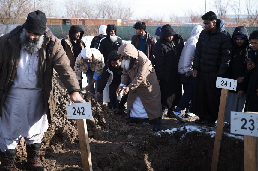 Community members and loved ones toss soil on the burial site of Nurul Amin Shah Alam in Buffalo, New York, on Thursday.