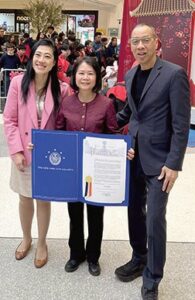 Ung presented a New York City Council Procla­mation to Flushing Li­brary Director Yang Zeng. Pictured with them is Queens Public Library President & CEO Dennis Walcott.