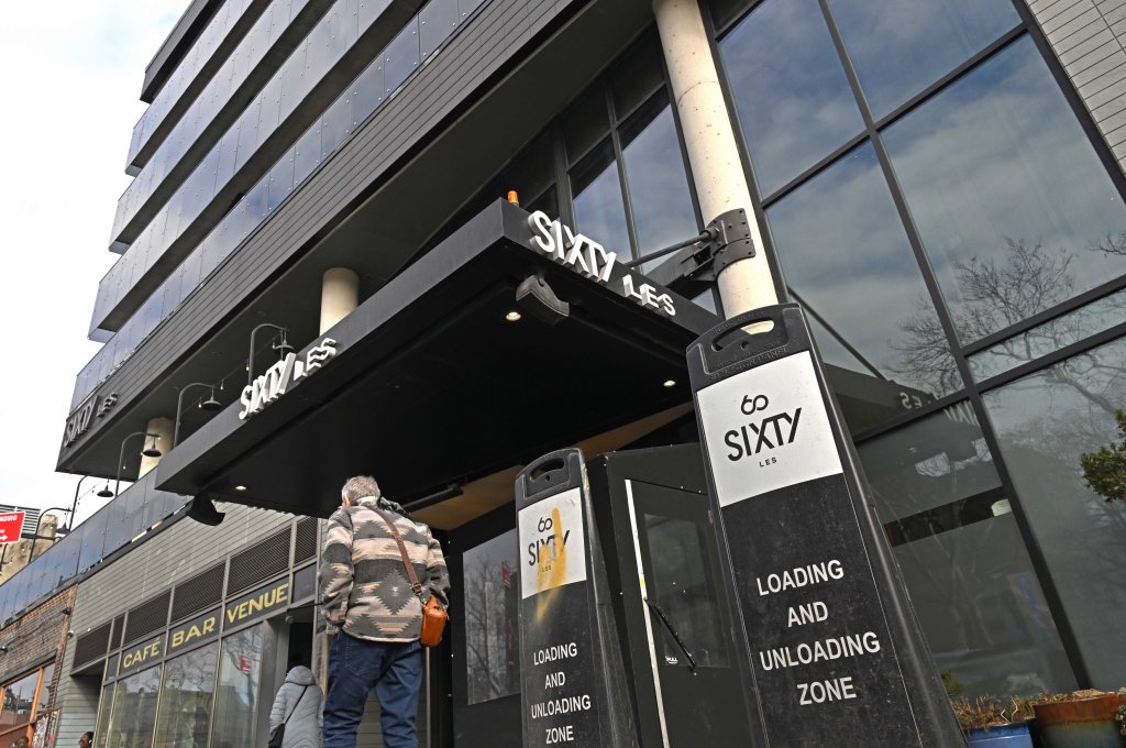 Exterior of the SIXTY LES hotel in Manhattan with loading/unloading zone signs outside.