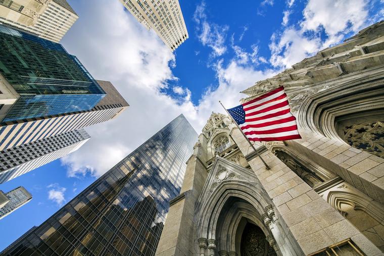 American flag waves in the wind outside St Patrick's Cathedral in Manhattan, New York.