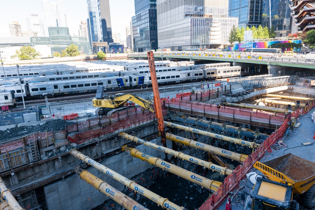 Construction of the Hudson Gateway Tunnel in New York City, with several trains visible in the background.