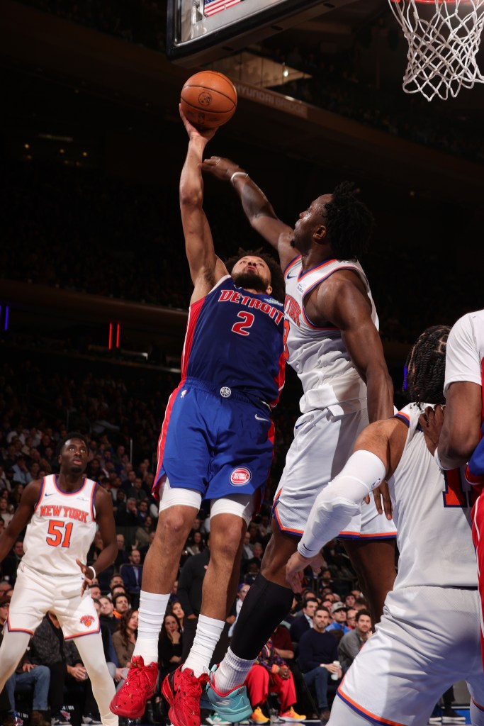 Cade Cunningham of the Detroit Pistons goes for a shot while being defended by a New York Knicks player.