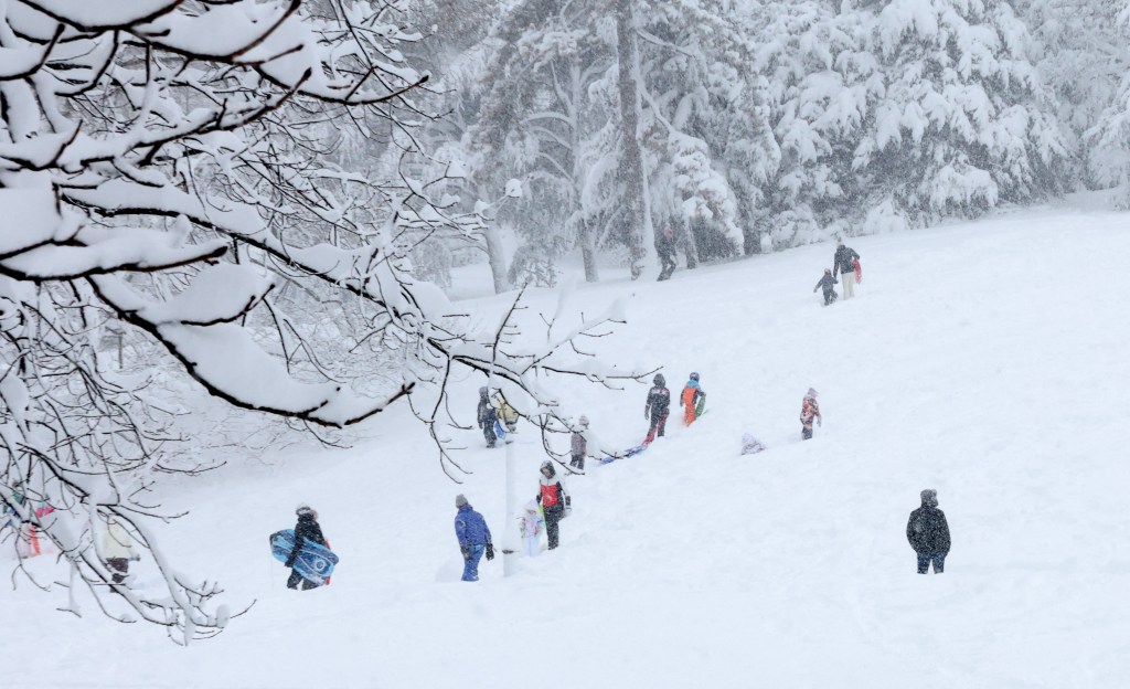 Children sled on Cedar Hill in Central Park in New York on February 23, 2026 during a snow storm. 