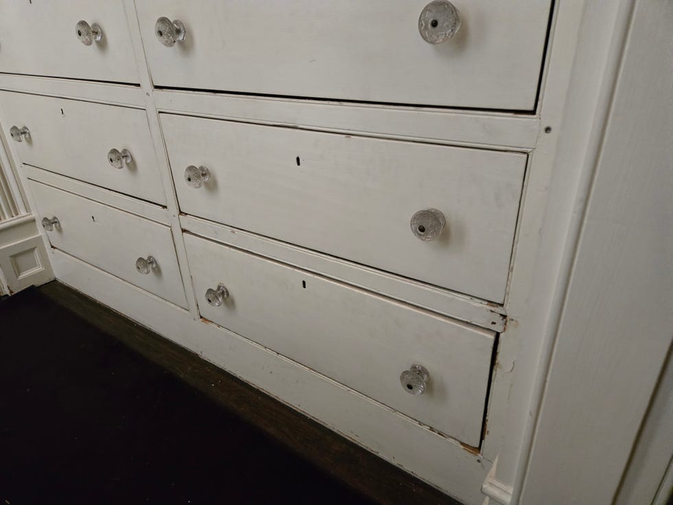 white wooden dresser with multiple drawers and metallic knobs