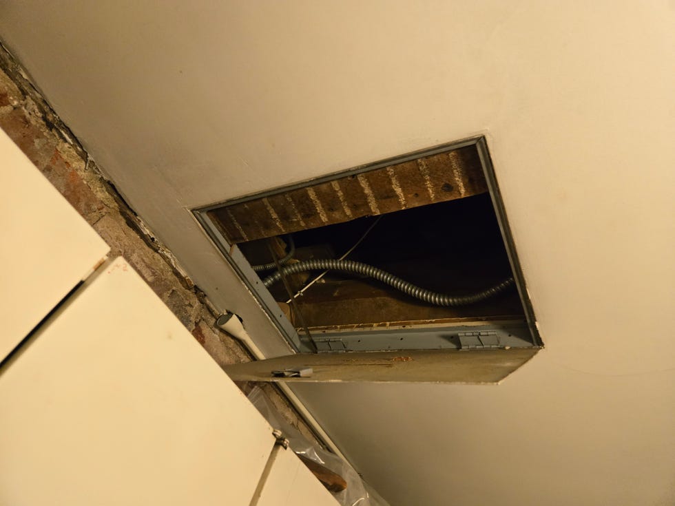 access point in the ceiling revealing insulation and plumbing
