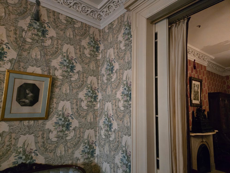 interior of a room featuring patterned wallpaper and an ornate frame