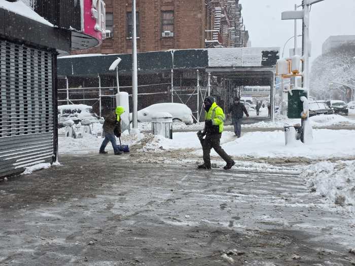 Shovelers clear the sidewalk at East 138th Street and Brook Ave in the South Bronx