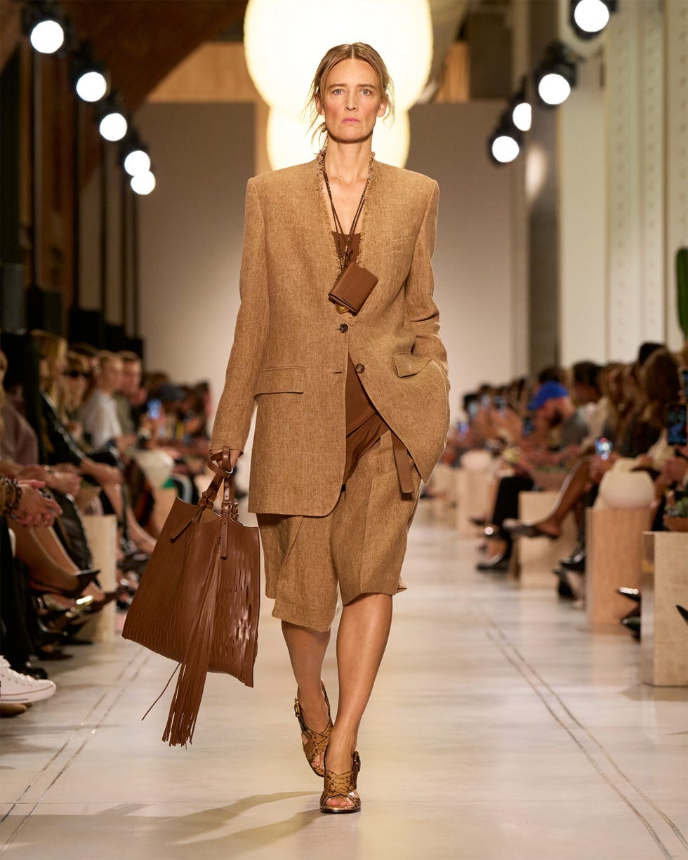 Model walking on a runway in a fashion show.