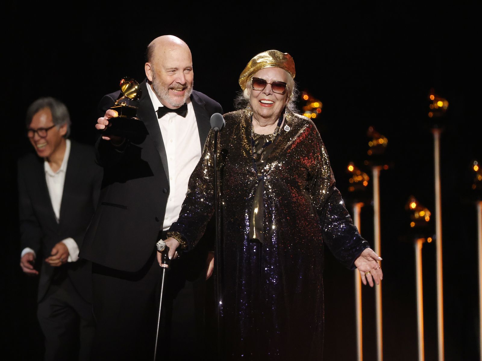 Image may contain Joni Mitchell Clothing Coat Face Head Person Photography Portrait Lighting Formal Wear and Suit