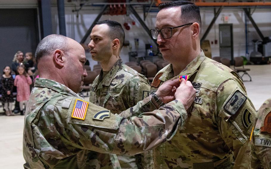 A uniformed soldier receives a military medal.