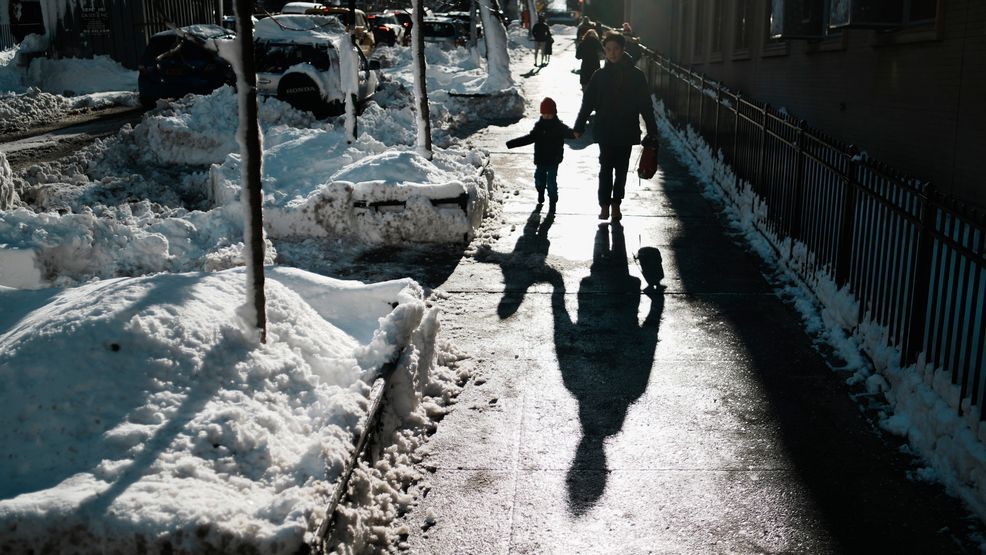 A man walks a boy to school, Tuesday, Feb. 24, 2026, in New York. (AP Photo/Eduardo Munoz Alvarez)