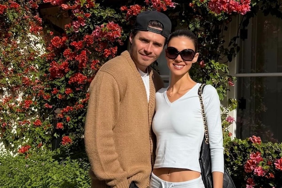 Brooklyn Beckham and Nicola Peltz posing with a dog on a leash