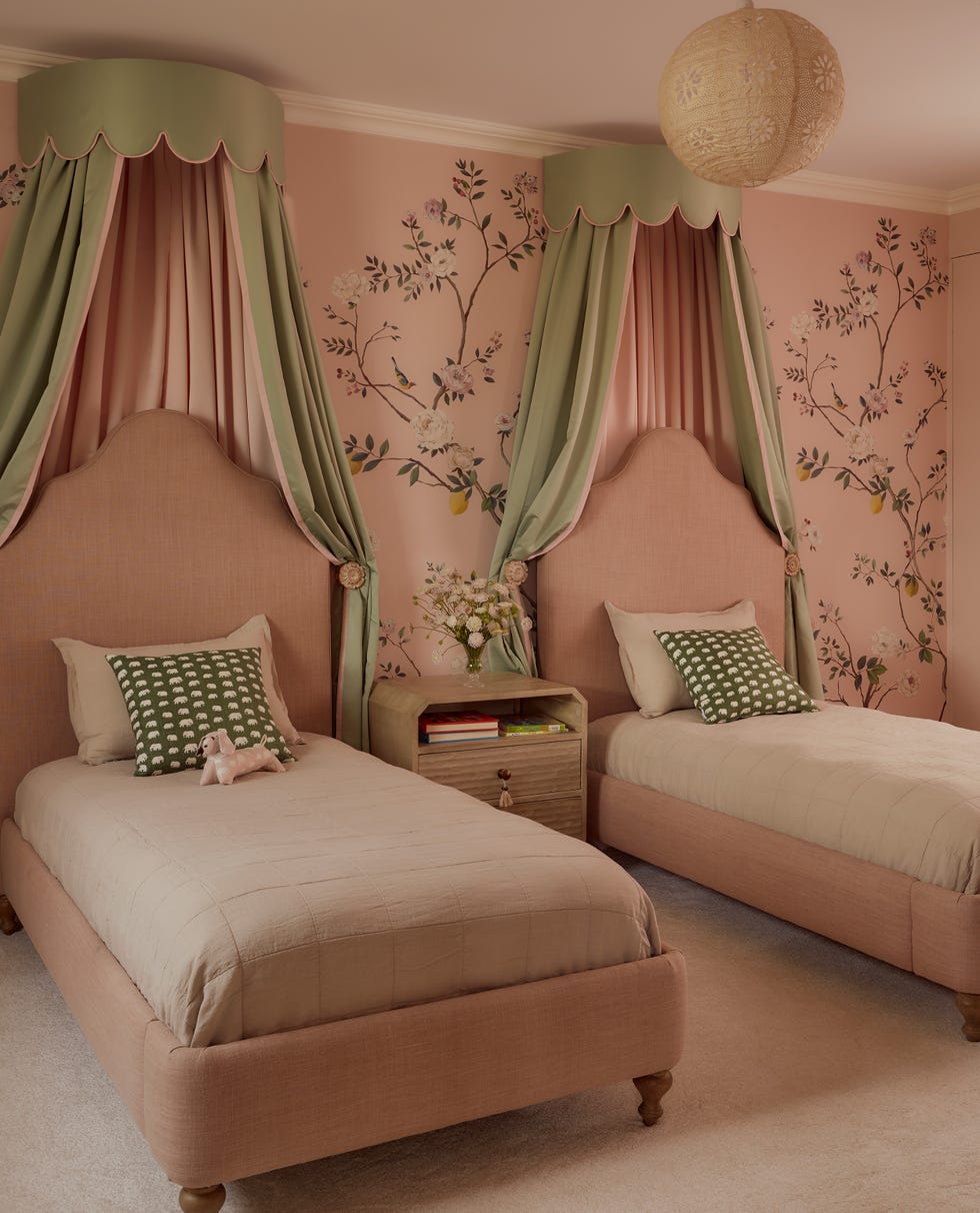 Children's bedroom with two beds and floral wallpaper.