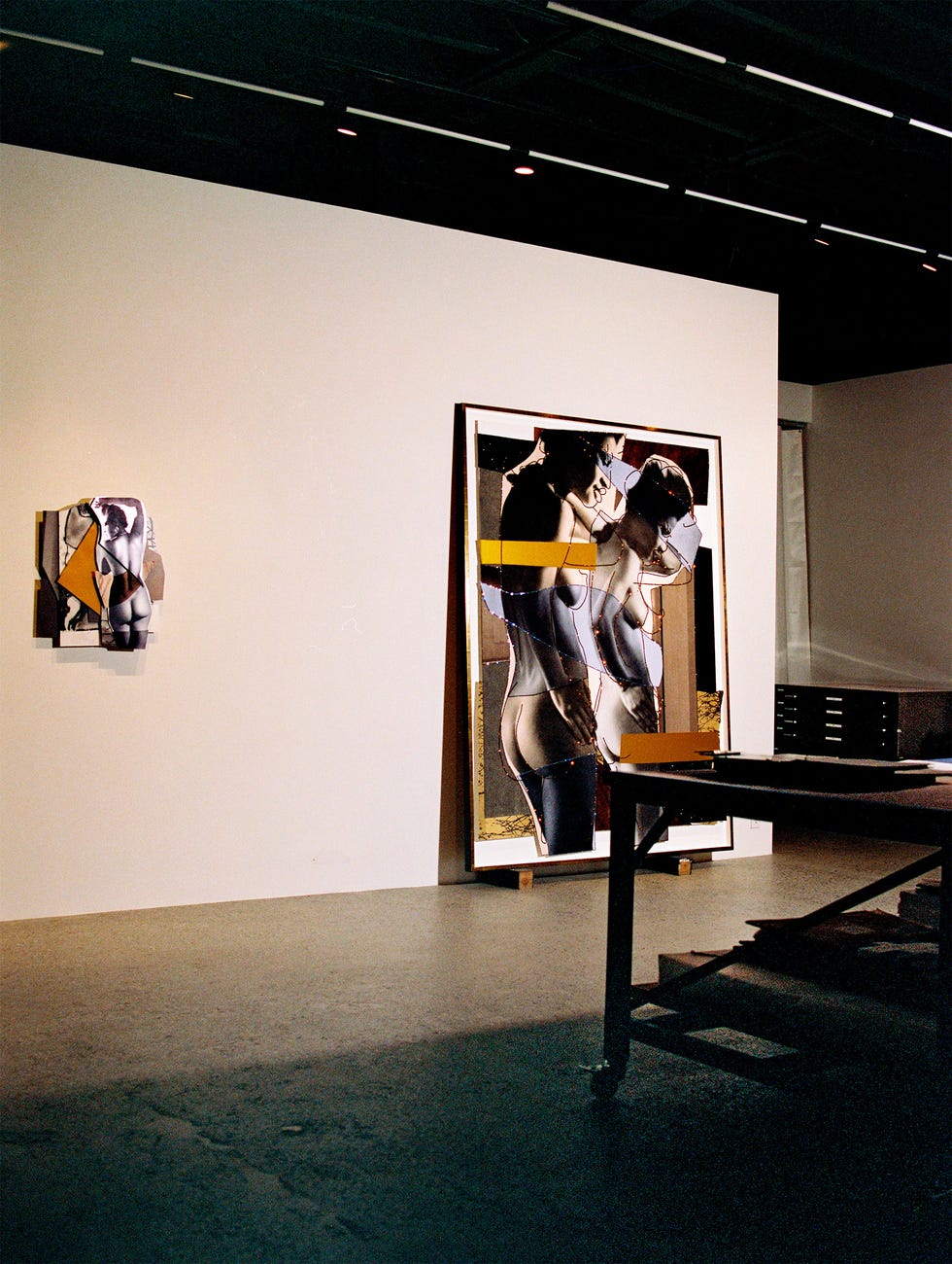 Art exhibition featuring mixed media artworks on display.