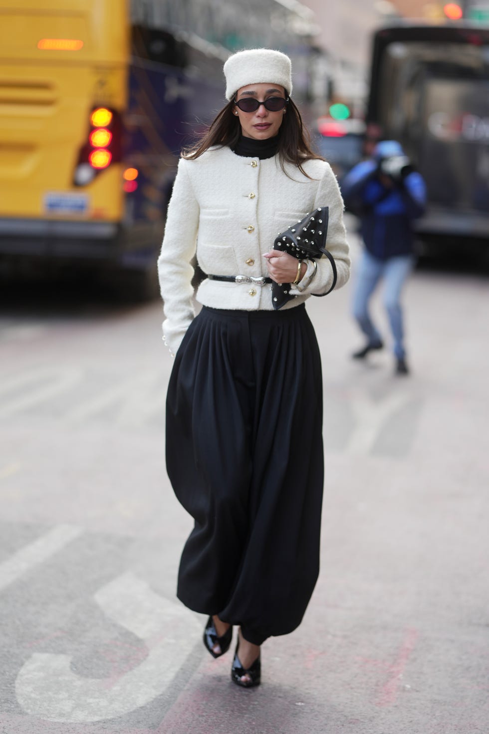 new york, new york february 14 blanca arimany is seen wearing a white pillbox hat, black sunglasses, gold stud earrings, a white bouclé buttonup jacket, a black turtleneck, a black leather belt with silver hardware, black voluminous harem trousers, and black patent leather opentoe heels, while carrying a black leather clutch with silver stud detailing during new york fashion week fall winter 2026 on february 14, 2026 in new york city photo by 305picsgetty images