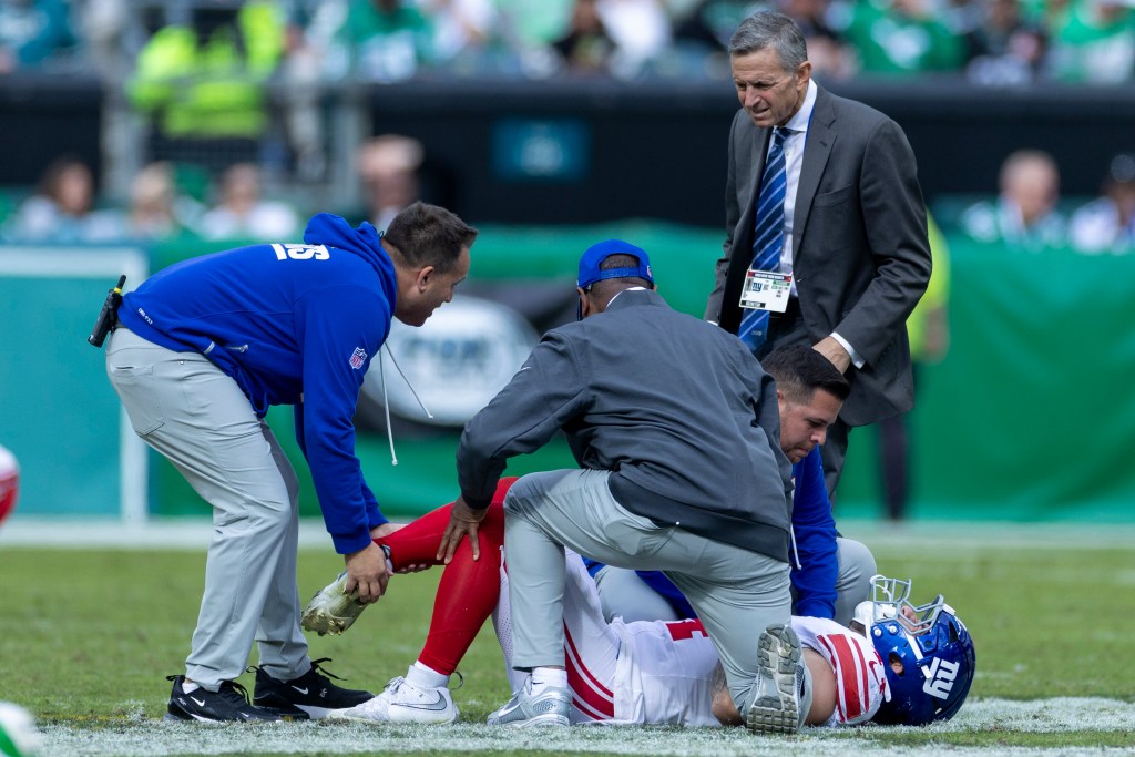 Trainers checking on New York Giants running back Cam Skattebo (44) after he twisted his ankle.