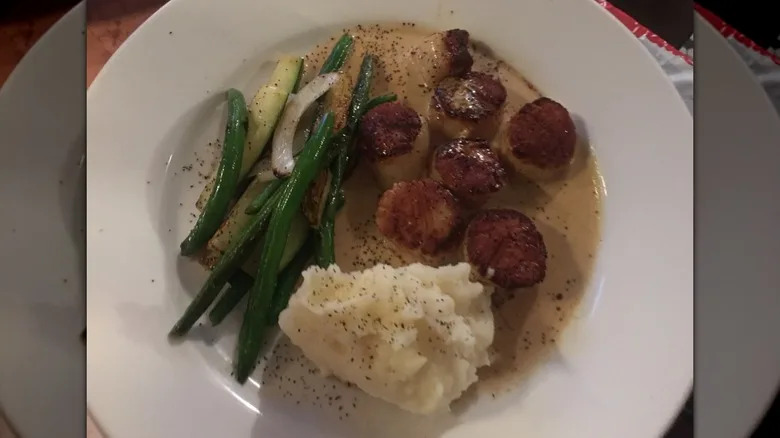 A plate of scallops and veggies at Petite Crevette.