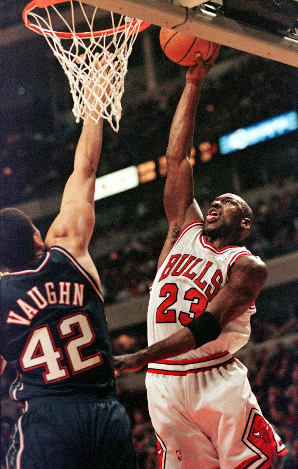 Michael Jordan (R) guard for the Chicago Bulls drives to the basket as he is covered by New Jersey Nets forward David Vaughn during the first quarter 16 March at the United Center in Chicago, Illinois. AFP PHOTO/VINCENT LAFORET (Photo by VINCENT LAFORET / AFP) (Photo credit should read VINCENT LAFORET/AFP via Getty Images)