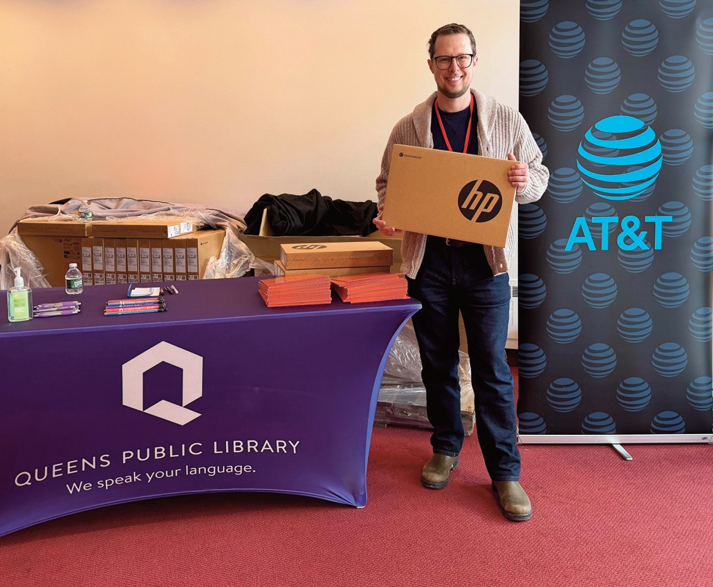 QEDC Executive Director Ben Guttmann held a computer during the giveaway.