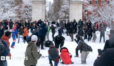 Dozens of people play and throw snowballs in New York's Washington Square Park