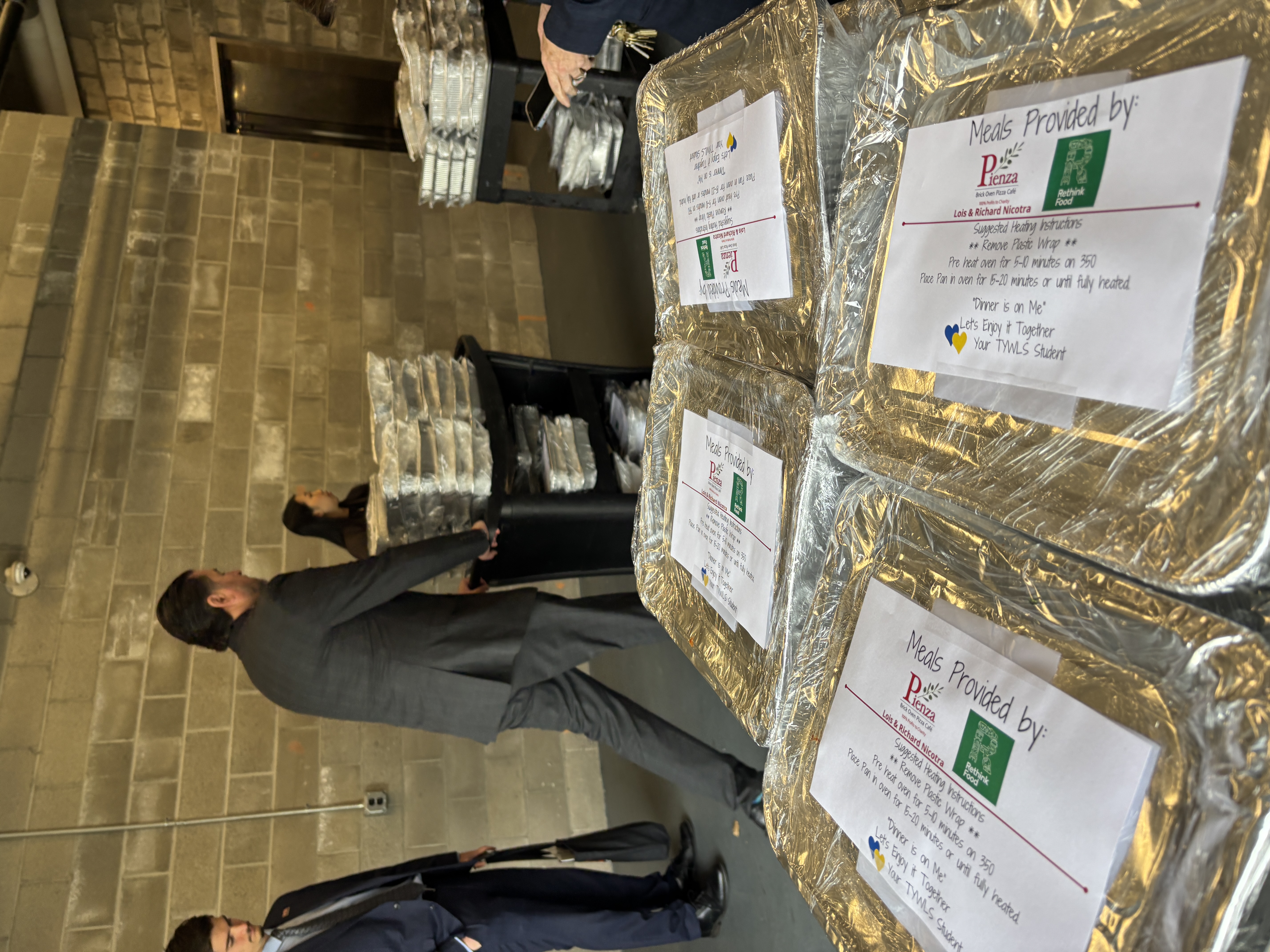 So much is happening in this moment — a glimpse into the quiet generosity that has become the Nicotras’ signature. Each of these meals carries a handwritten note for the families who will receive them, part of the “Dinner Is On Me!” program that delivers free, well‑balanced dinners to students and their households. It’s food as care, packed with intention, and another example of how the Nicotras keep showing up for Staten Island.