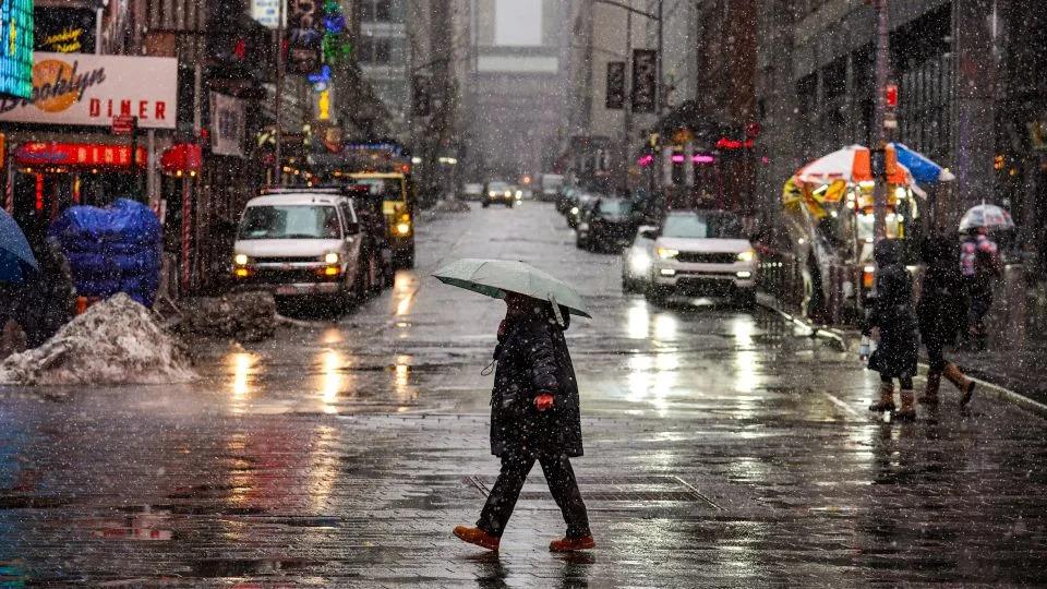People walk along the street during snowfall on Sunday in New York City. - Ryan Murphy/Getty Images
