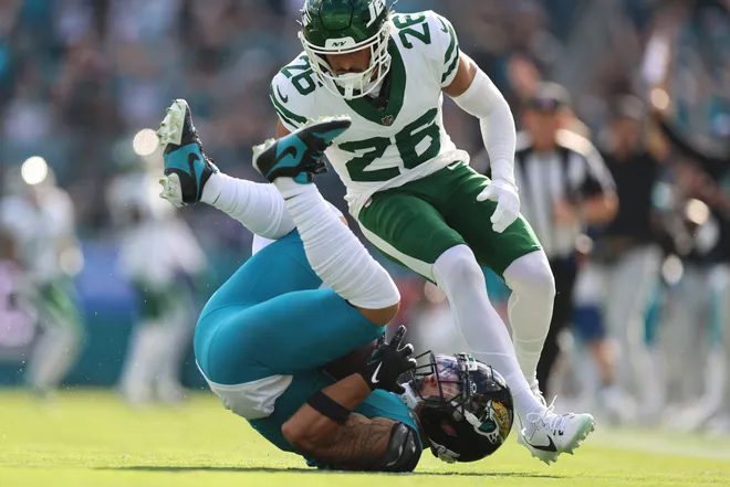 JACKSONVILLE, FLORIDA - DECEMBER 14: Parker Washington #11 of the Jacksonville Jaguars makes a catch defended by Isaiah Oliver #26 of the New York Jets during the second quarter at EverBank Stadium on December 14, 2025 in Jacksonville, Florida. (Photo by Mike Carlson/Getty Images)