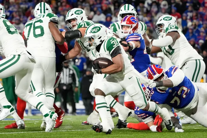 Jan 4, 2026; Orchard Park, New York, USA; New York Jets running back Khalil Herbert (31) avoids a tackle by Buffalo Bills defensive tackle Phidarian Mathis (72) during the third quarter at Highmark Stadium. Mandatory Credit: Gregory Fisher-Imagn Images