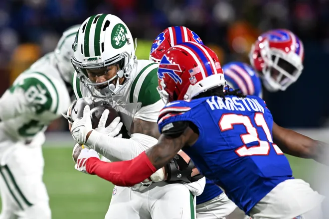 Jan 4, 2026; Orchard Park, New York, USA; New York Jets wide receiver John Metchie III (3) carries the ball defended by Buffalo Bills cornerback Maxwell Hairston (31) during the fourth quarter at Highmark Stadium. Mandatory Credit: Mark Konezny-Imagn Images