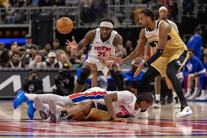 Feb 5, 2026; Detroit, Michigan, USA; Detroit Pistons guard Ausar Thompson (9) battles for a loose ball with Washington Wizards guard Bub Carrington (7) as Pistons forward Isaiah Stewart (28) and Wizards center Alex Sarr (20) react during the second half at Little Caesars Arena.