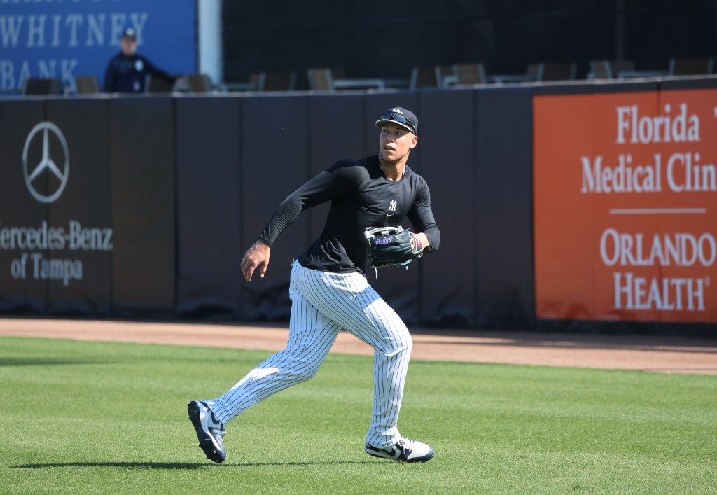 New York Yankees right fielder Aaron Judge in uniform, looking to catch a fly ball during spring training.