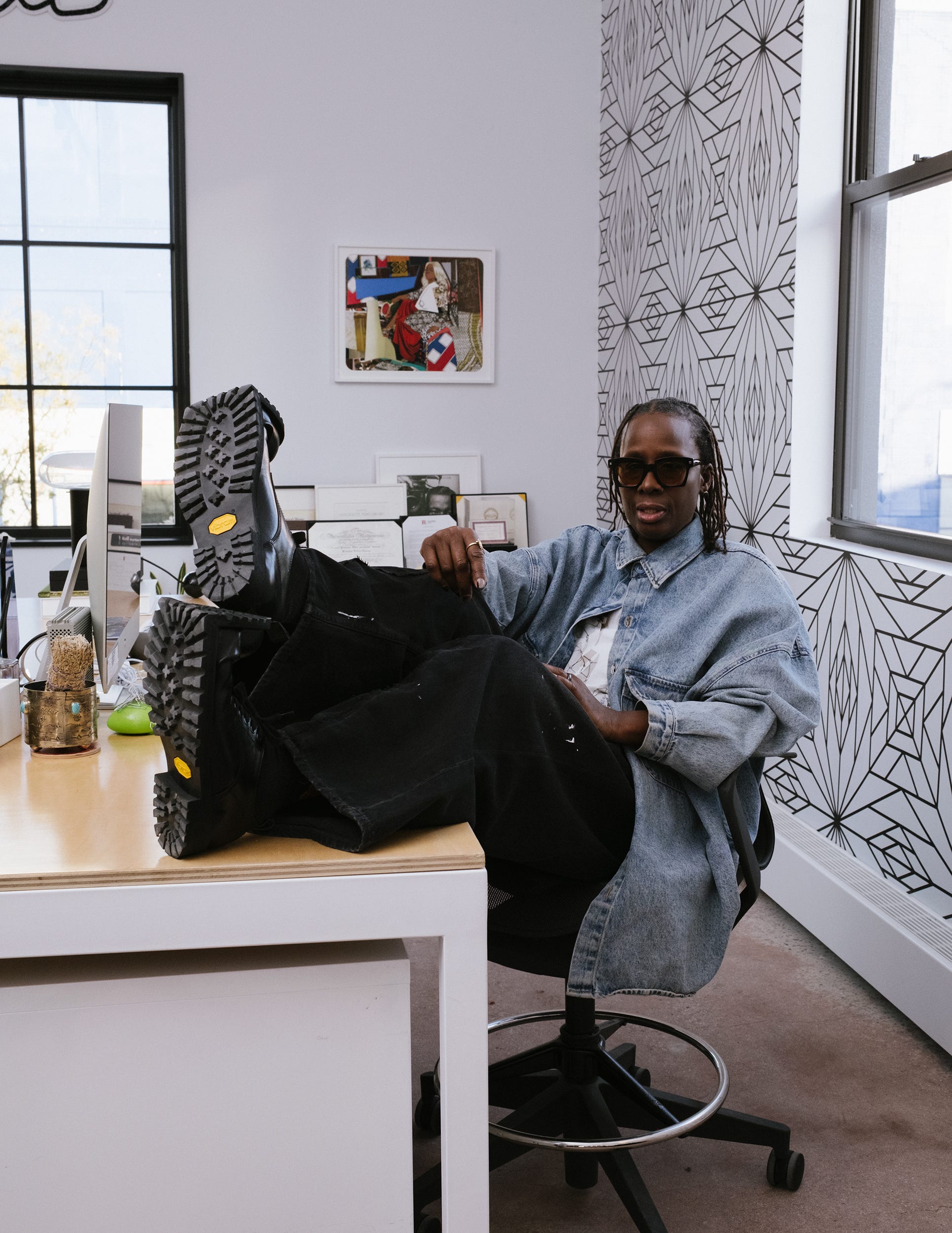 Seated person with feet on a desk in an office setting.