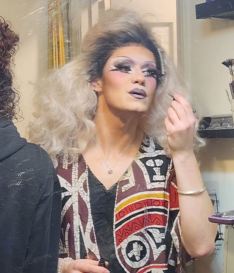 Venus Wyre applying eyeliner in her tiny bathroom.