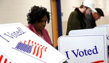 Voters fill out their ballots at a polling place