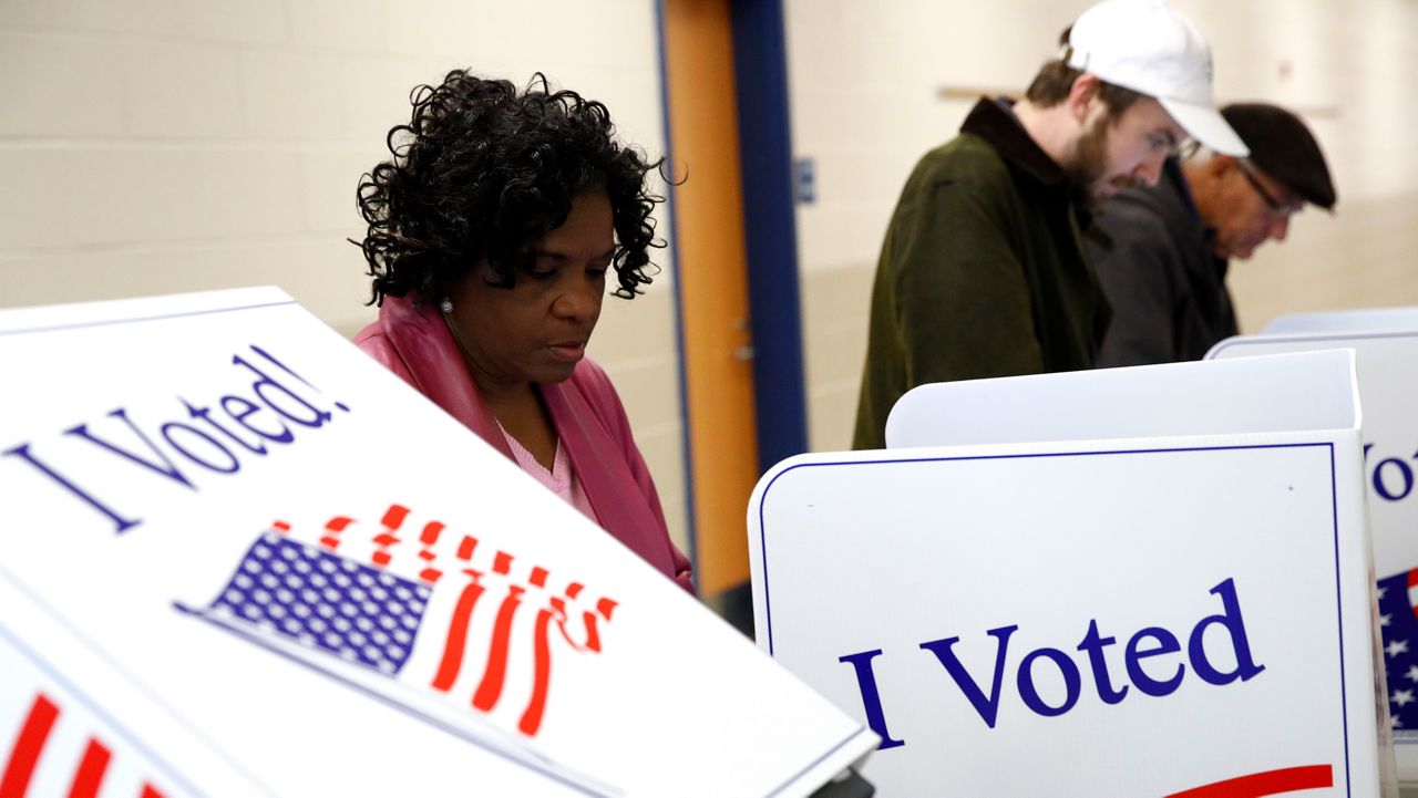 Voters fill out their ballots at a polling place