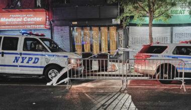 New York City Police Department vehicles secure the entrance to the Taste of the City Lounge, center, where a shooting took place on Aug. 17 in Crown Heights. AP Photo/Julie Walker, File