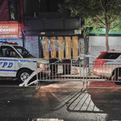 New York City Police Department vehicles secure the entrance to the Taste of the City Lounge, center, where a shooting took place on Aug. 17 in Crown Heights. Photo: Julie Walker/AP, File