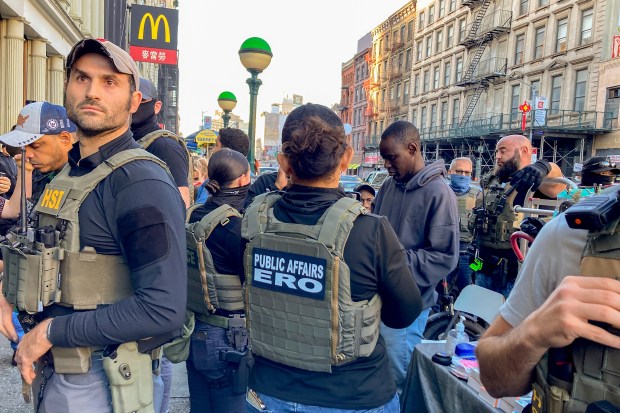 Federal agents conduct an immigration sweep on Canal Street in Chinatown, Tuesday, Oct. 21, 2025, in New York.