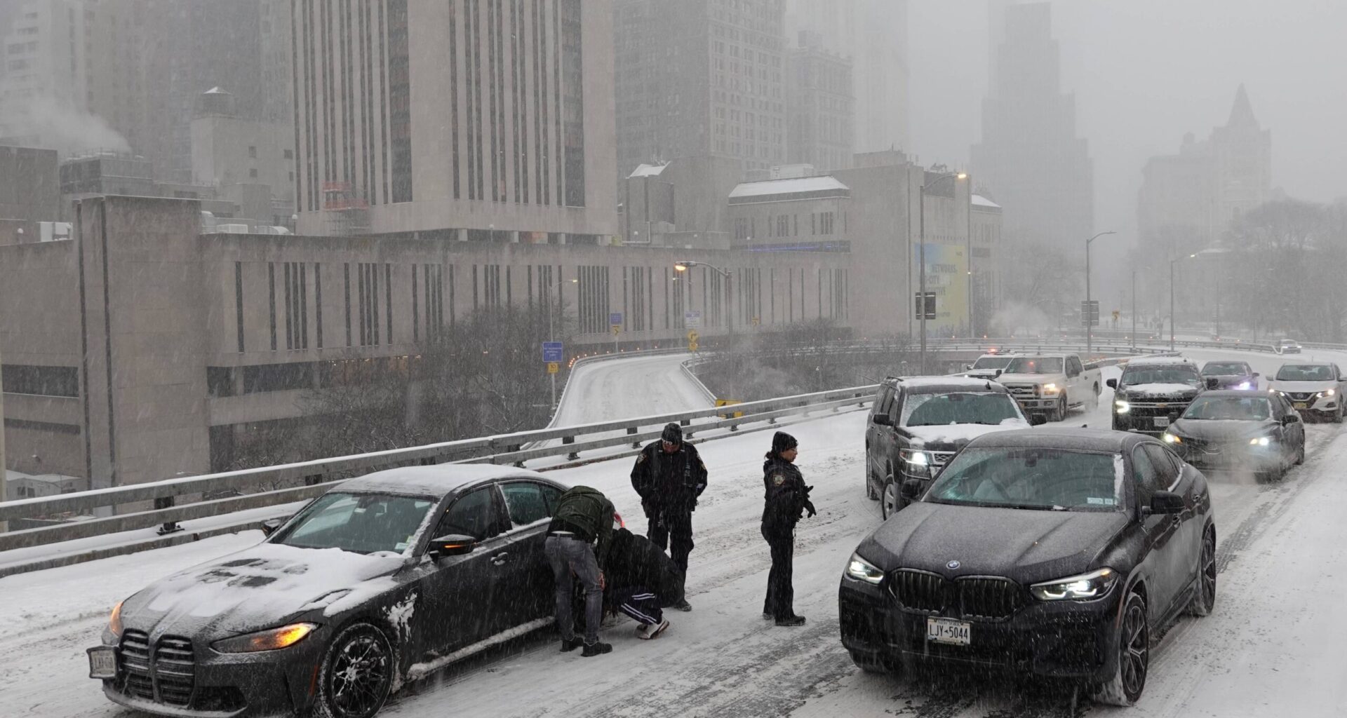 Police direct traffic past a car stuck going across the Brooklyn Bridge as it snows on Sunday, Jan. 25, 2026, in New York. Photo: Alyssa Goodman/AP