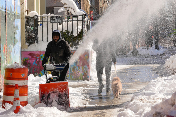A worker uses a snow blower to clear snow from a sidewalk in front of retail shops, Tuesday, Feb. 24, 2026, in the Brooklyn borough of New York. Photo: Yuki Iwamura/AP