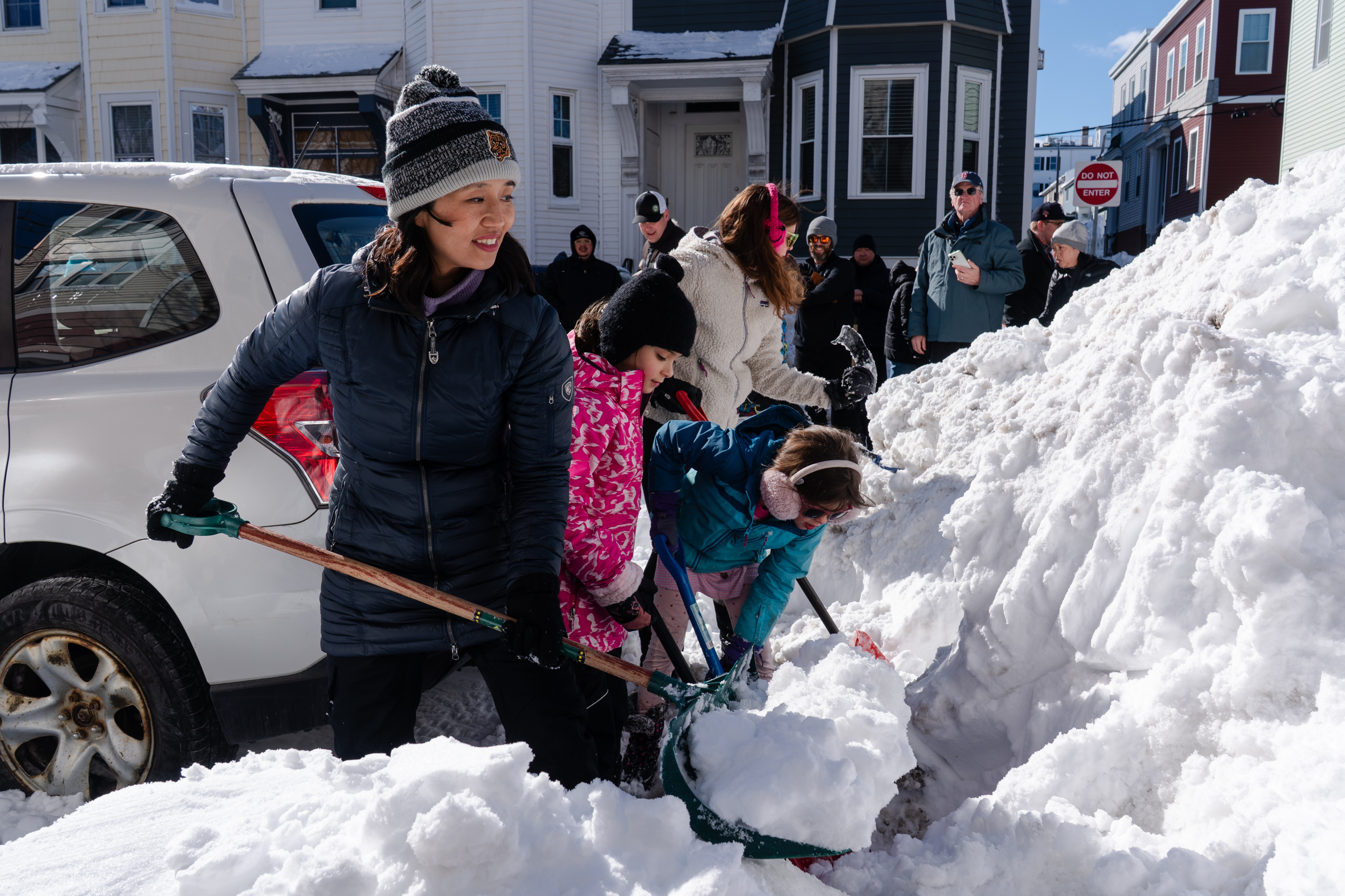 Boston Mayor Michelle Wu lends a hand shoveling snow from around a fire hydrant.