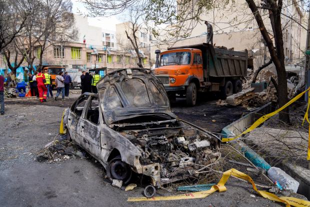 A damaged car remains on the ground in the aftermath of an Israeli-U.S. strike in Tehran, Iran, Saturday, Feb. 28, 2026. (AP Photo/Amir Kholousi/ISNA)