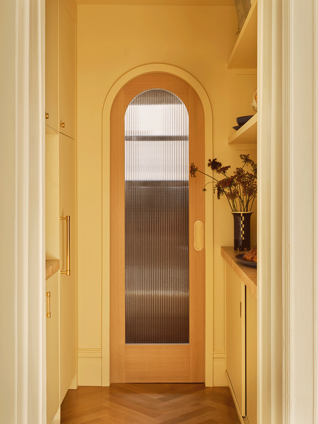 gif of yellow hallway ending in arched powder room door