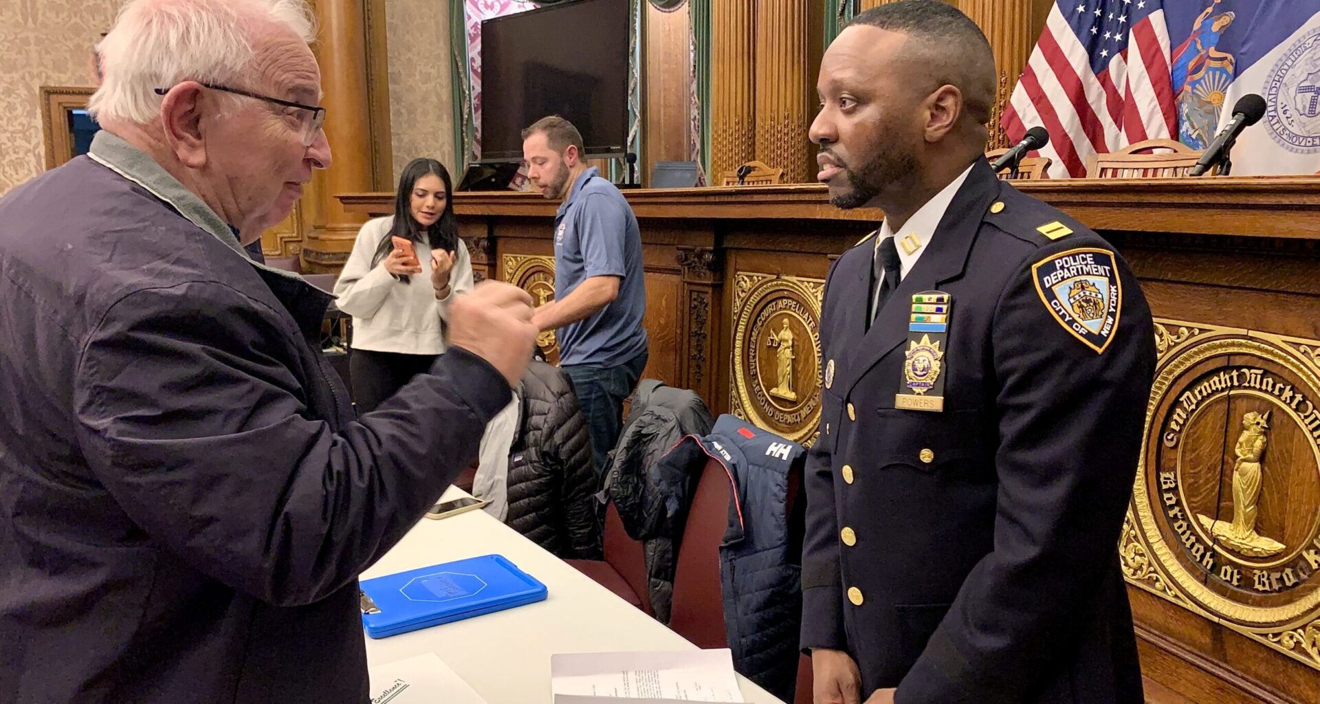 Captain Erek Powers speaks with a local resident at the 84th Precinct Community Council meeting on Jan. 20, 2026. Photo: Mary Frost, Brooklyn Eagle
