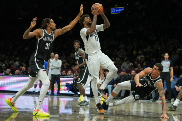 Dallas Mavericks' Naji Marshall (13) drives past Brooklyn Nets' Nic Claxton (33) and Michael Porter Jr. (17) during the first half of an NBA basketball game Tuesday, Feb. 24, 2026, in New York. (AP Photo/Frank Franklin II)