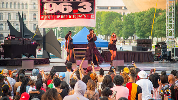A female trio performs on stage in front of a large audience at Empire State Plaza during the Black Arts & Cultural Festival.