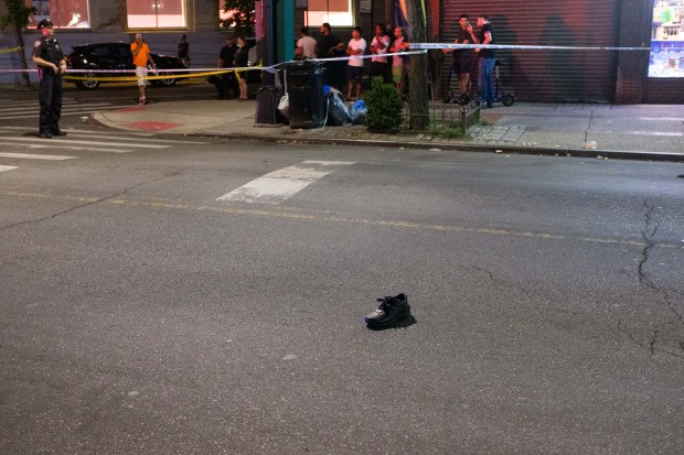 A shoe is seen in the street as the NYPD Highway Patrol investigates after a man, identified as Be Tran, was fatally struck by a car on Myrtle Ave. and Seneca Ave. in Queens, New York, on Sunday, Aug. 14, 2022. (Gardiner Anderson for New York Daily News)