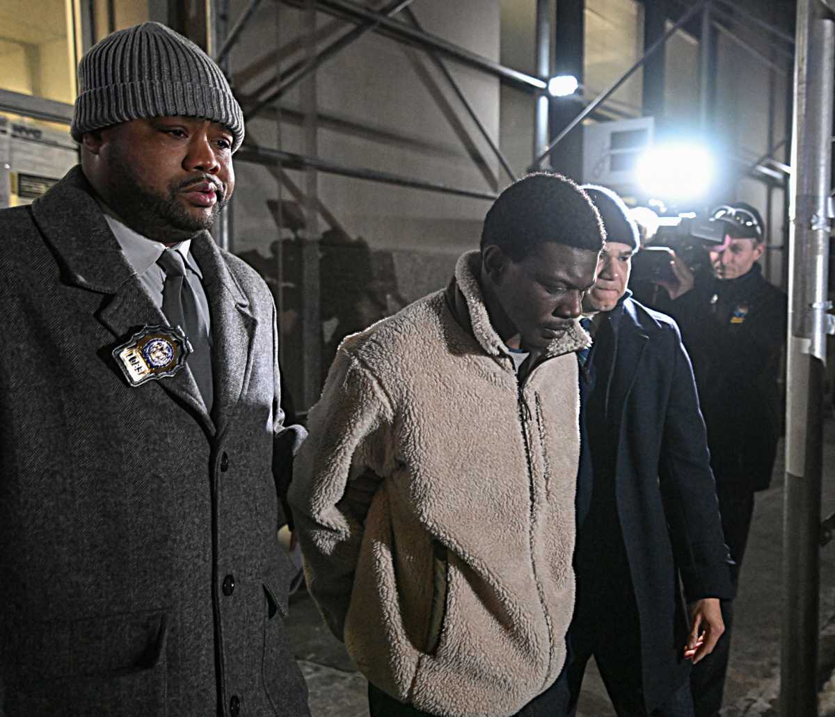 Suspect in Manhattan rape case has head bowed while escorted by detectives following arrest