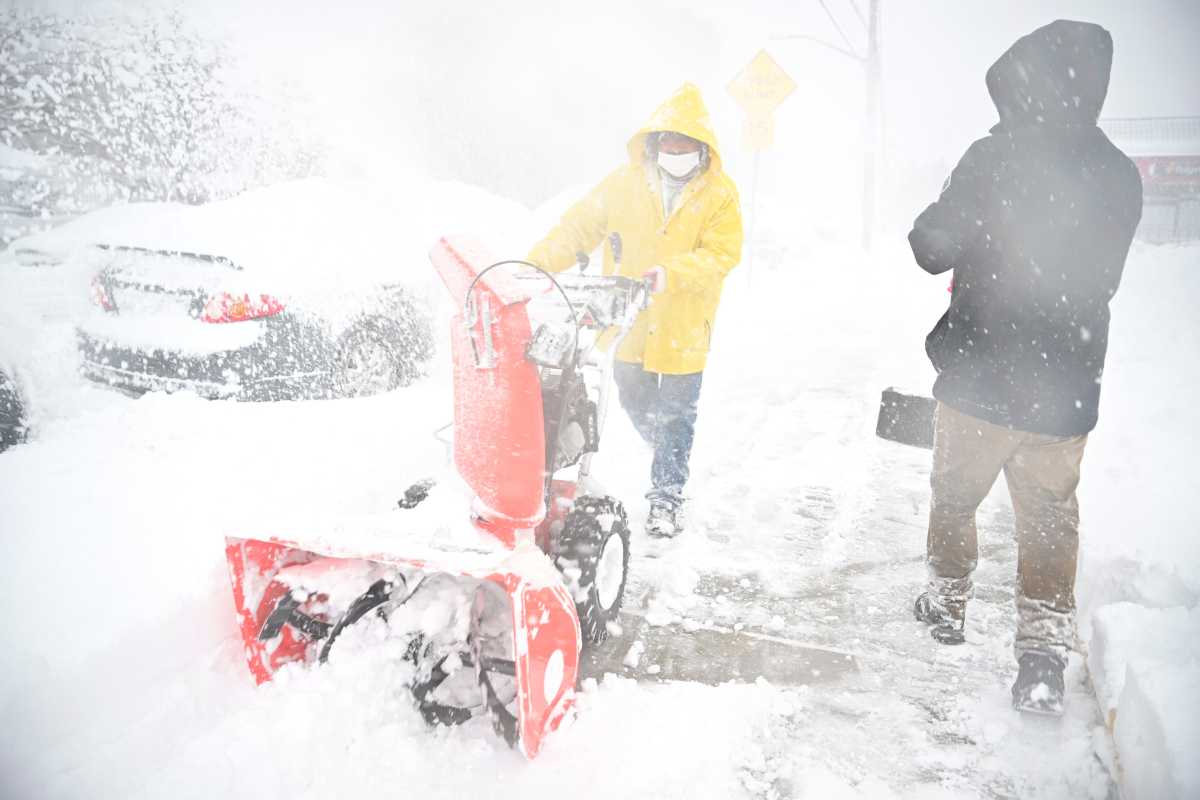 people shoveling sidewalks in Brooklyn during NYC blizzard